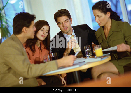 Team of associates collaborating in cafe Stock Photo