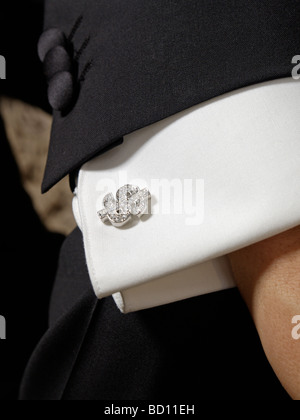 bling bling closeup of a dollar sign silver with diamonds cufflink tuxedo smoking suit Stock Photo