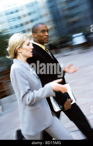 Businessman and businesswoman walking together in conversation Stock Photo