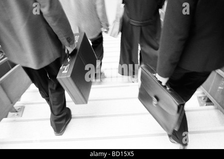 Business professionals with briefcases descending stairs Stock Photo