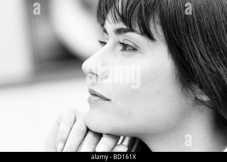 Young woman with hand under chin looking away, portrait Stock Photo