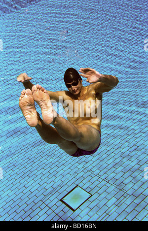 Male swimmer floating underwater in swimming pool Stock Photo