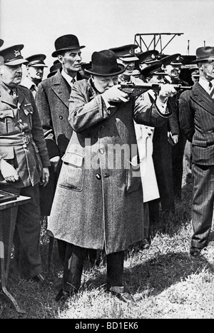 WINSTON CHURCHILL uses a Sten gun like a rifle during a visit to an armaments factory in June 1941.  See Description below Stock Photo