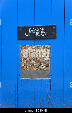 A funny Beware of the Cat sign above a cat entrance cut in a gate on the river front at Topsham Devon Uk Stock Photo