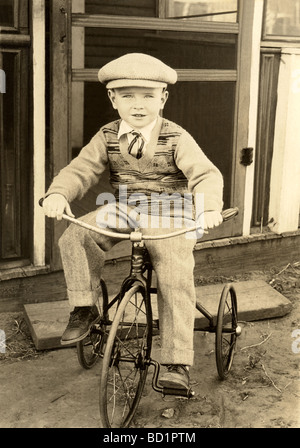 Fashionably Dressed Little Boy on Tricycle Stock Photo