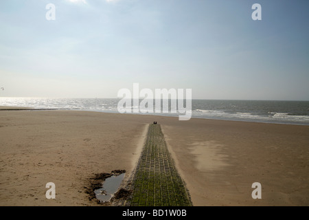 couple sitting on the empty beach in De Haan Belgium Stock Photo