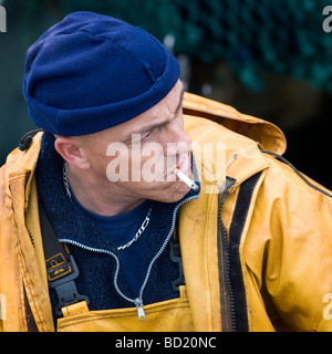 French fisherman smoking whilst working on fishing nets, Stock Photo