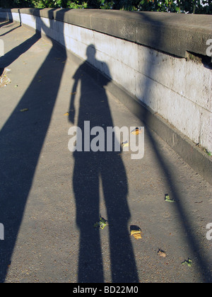 man's long shadow on pavement in city town Stock Photo