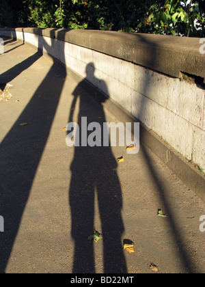 man's long shadow on pavement in city town Stock Photo