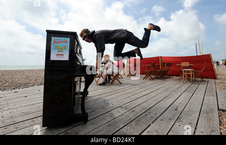 Man playing the piano on Worthing seafront beach Stock Photo