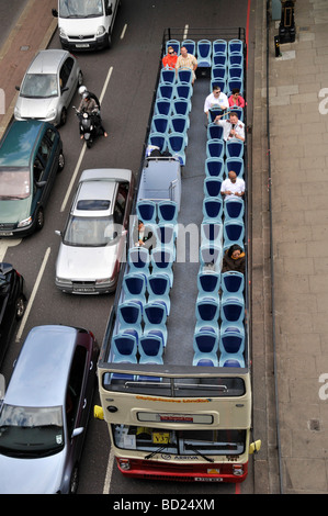 Aerial birds eye view looking town from above at top deck of London double decker hop on hop off nearly empty sightseeing tour bus England UK Stock Photo