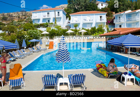Guests sunbathe around pool of hotel near Skala on the Greek Mediterranean island of Kefalonia Greece GR Stock Photo