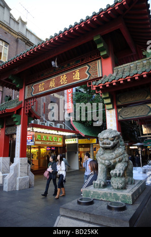Chinese lion guarding the gate (paifang) which indicates entry into the main part of Chinatown. Stock Photo