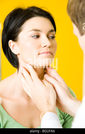 doctor checking woman's throat Stock Photo