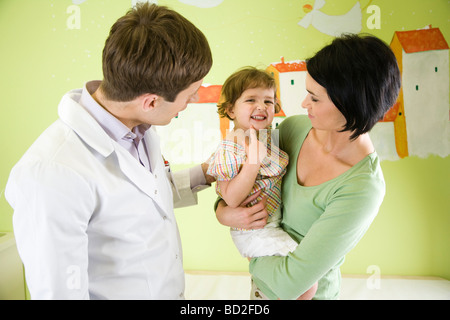 mother and daughter talking to doctor in exam room