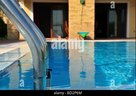 Focus on the chrome steps leading into a swimming pool Image taken in Albufeira Algarve Portugal Stock Photo