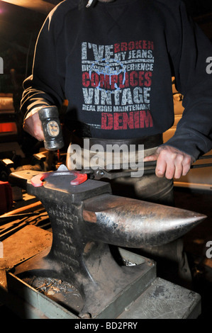 Farrier preparing a horseshoe in his mobile workshop Stock Photo