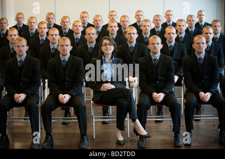 1 businesswoman with 25 men clones Stock Photo