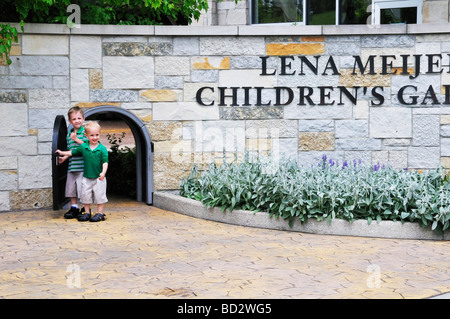 Children walk through the miniature gate at the Lena Meijer Childrens Garden part of the Frederik Meijer Gardens Sculpture Park Stock Photo