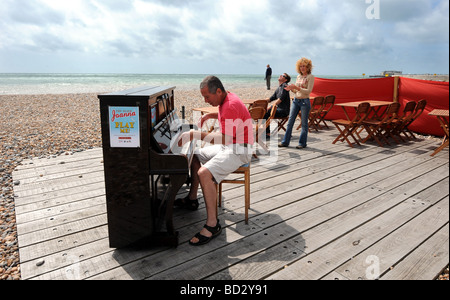 Man playing the piano on Worthing seafront beach Stock Photo