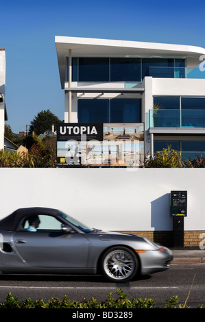 A SPORTS CAR PASSES A PAY AND DISPLAY PARKING TICKET MACHINE OUTSIDE A PROPERTY DEVELOPMENT CALLED UTOPIA ON SHORE ROAD NEAR SAN Stock Photo