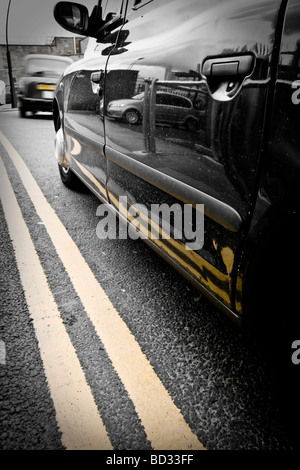 Black taxi cabs waiting outside Sheffield train station, on double yellow lines. Stock Photo
