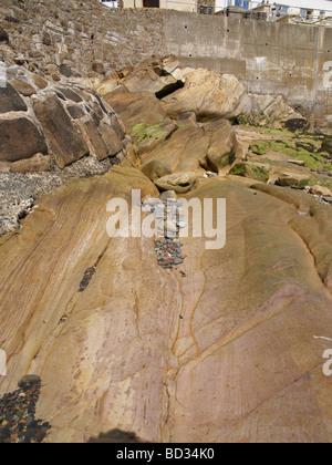 Colourful water worn stone pebbles captured in a rock gully at low tide Stock Photo