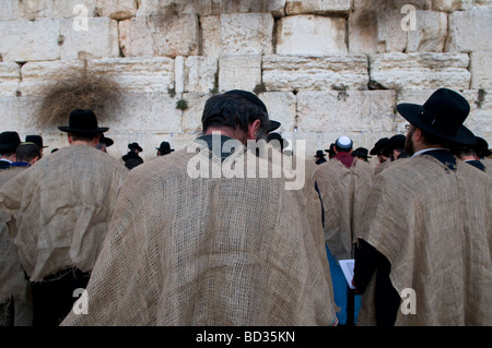 Haredi Jews wearing jute bag to signify grief pray on Tisha B'Av commemorating the destruction of the First and Second Temple in the Western Wall Stock Photo