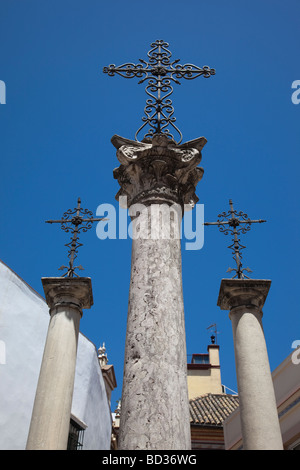 Three ornate metal crosses on columns in Santa Cruz square, Seville, Andalusia, Spain Stock Photo