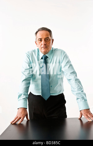 Manager leaning on his desk Stock Photo