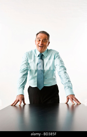 Manager leaning on his desk and laughing Stock Photo