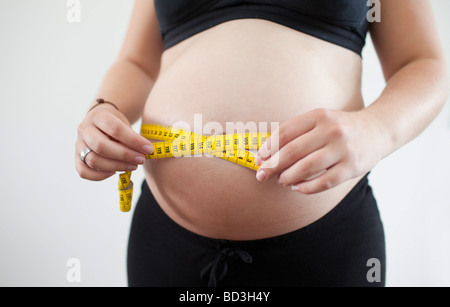 Pregnant woman measuring her abdominal grith Stock Photo