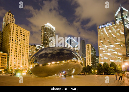 Anish Kapoor sculpture Cloud Gate aka the Bean at night with city behind Millennium Park in Chicago Illinois Stock Photo