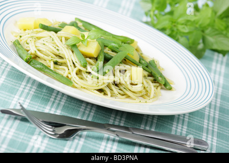 Spaghetti with cheese, string beans, and pesto sauce Stock Photo