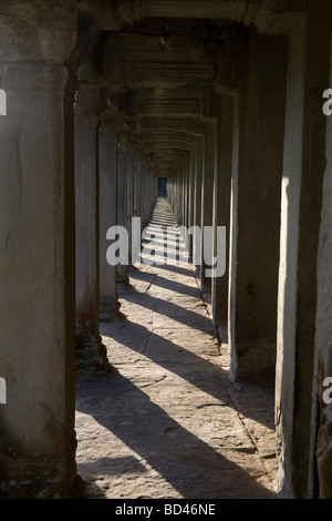 Shafts of light shine through a long row of pillars inside Angkor Wat, Cambodia Stock Photo