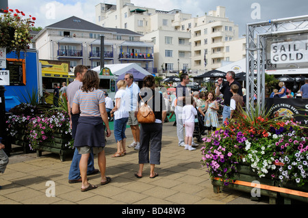 Cowes regatta week visitors relaxing on The Parade a waterfront area of catering bars and food outlet tents Isle of  Wight UK Stock Photo