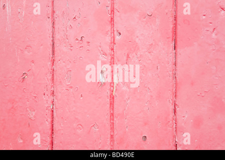 Closeup of wood panels with peeling pink paint Stock Photo