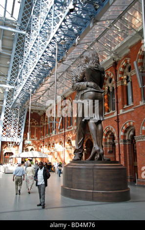 Passengers walk past 'The Meeting Place' by sculptor Paul Day, St Pancras International Railway Station, London, UK. Stock Photo