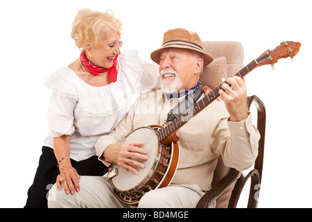 Senior man courts his lady love by playing banjo for her Isolated on white Stock Photo