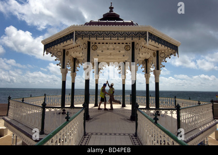Two burly builders in hard hats and safety vests dance to celebrate the million pound refurbishment of Brighton bandstand. Stock Photo