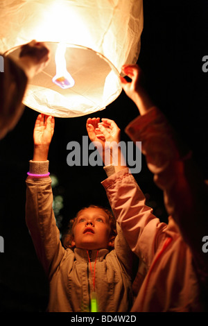 kids launch a sky lantern; Thai lantern; floating lantern; model release available for the girl in the center Stock Photo