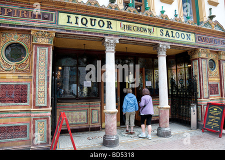 Two people entering the famous Crown Liquor Saloon in Belfast, which is owned and was restored by the National Trust and is a Grade A listed building. Stock Photo