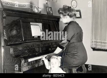 Mother at Player Piano with Daughter Stock Photo