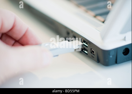 A hand plugging in a universal serial bus Stock Photo