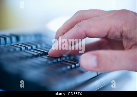 Hand typing on a computer keyboard Stock Photo