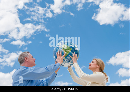 two people holding up a globe Stock Photo