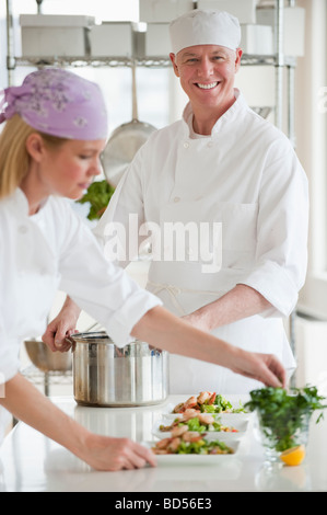 Chefs making salad in a kitchen Stock Photo