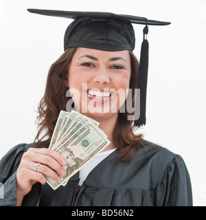 A graduate holding money Stock Photo