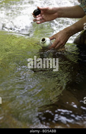 A man with a reusable water bottle in the woods Stock Photo