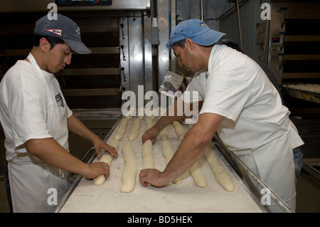 Workers at Amy s Bread in Chelsea Market in New York bake loaves of bread in the bakery s commercial ovens Stock Photo